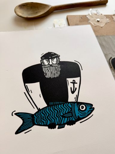a hand printed multiblock linocut print of a sailor and fish